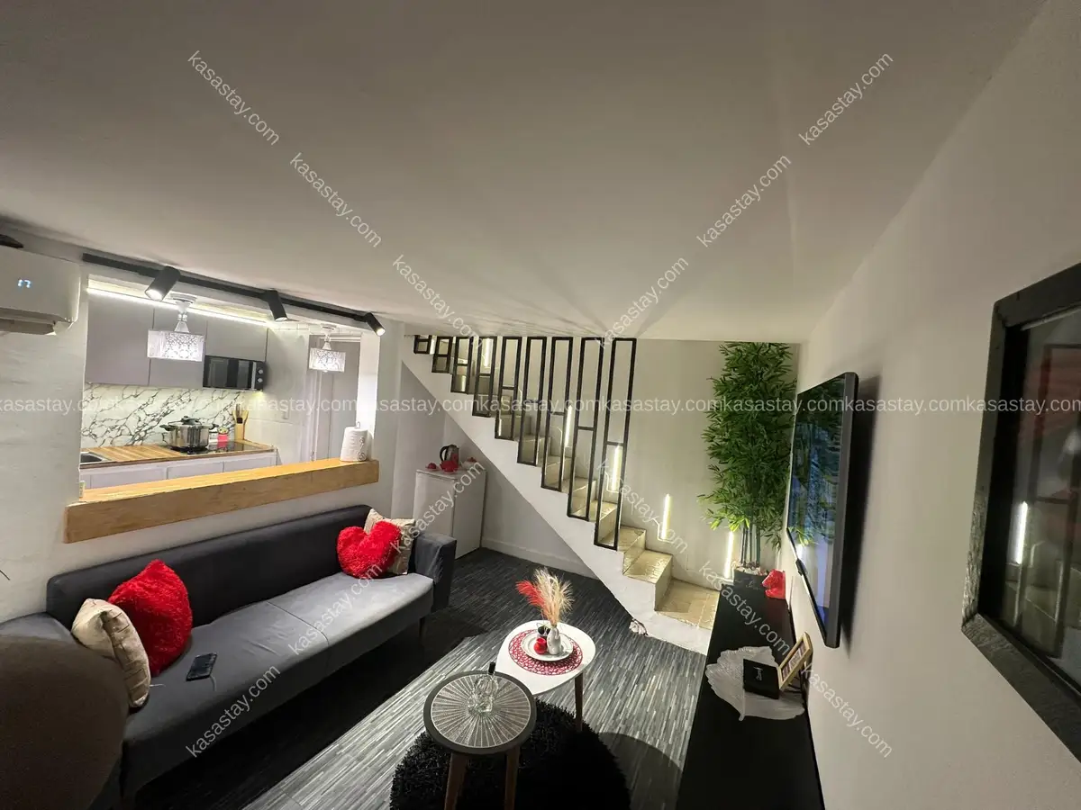 Studio moderne et chaleureux avec escalier design.
